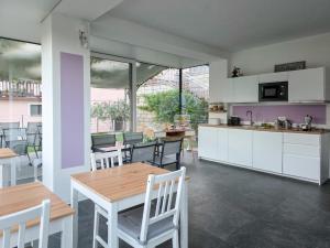 a kitchen with white cabinets and a table and chairs at Bed and Breakfast AnnA in Isera