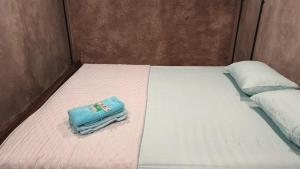 a bed with a blue towel on top of it at Omah Masayu in Yogyakarta