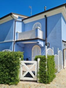 a blue house with a white gate in front of it at La Piazzetta Affittacamere B&B in Numana