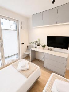 a white living room with a desk and a tv at APARTAMENT 4 bed 2 room WARSAW in Warsaw