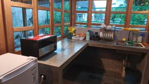 a kitchen with a counter top with a microwave at Omah Masayu in Yogyakarta