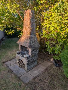 a stone fireplace sitting in the middle of a yard at Your home in Gohrisch in Kurort Gohrisch +5 photos