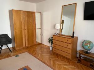a living room with a dresser and a mirror at Viktória central apartman in Odorheiu Secuiesc
