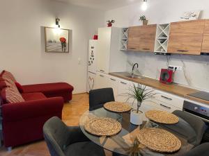 a living room with a table and a kitchen at Viktória central apartman in Odorheiu Secuiesc