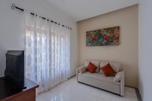 a living room with a couch and a tv at Boutique Dinu in Kandy