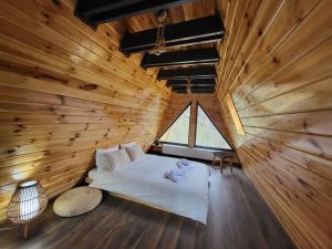 a bedroom with a bed in a wooden room at Hill House Doftana in Seciuri