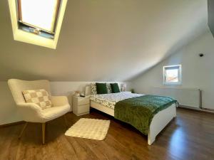a bedroom with a bed and a chair and a window at Stari grad 2 in Valjevo +4 photos