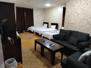 a hotel room with two beds and a couch at Siveen Hotel in Amman +54 photos