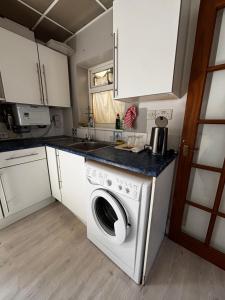 a kitchen with a washing machine and a sink at Stylish Studio with SuperKing Bed in Stonewood