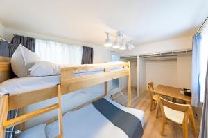 a room with two bunk beds and a table at 第2舞鶴ハイツ in Fukuoka