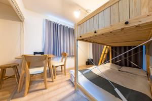 a bedroom with a bunk bed and a table and chairs at 第2舞鶴ハイツ in Fukuoka