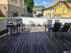 a deck with tables and chairs on a building at BlumentrittAppartment in Sankt Aegyd am Neuwalde