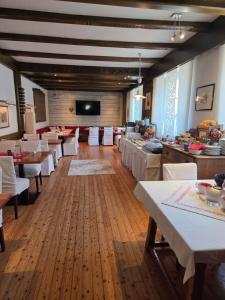 a dining room with white tables and a flat screen tv at BlumentrittAppartment in Sankt Aegyd am Neuwalde