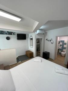 a bedroom with a white bed and a flat screen tv at Casa XX Settembre Deluxe in Misterbianco