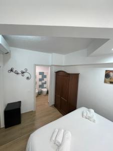 a bedroom with a white bed with two towels at Casa XX Settembre Deluxe in Misterbianco