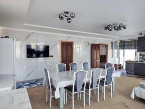 a dining room with a white table and chairs at Эко Жайлоо in Kaji-Say