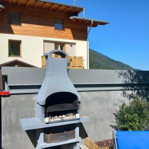 a outdoor pizza oven on the side of a house at Casa Penasa Appartamento 1 in Commezzadura
