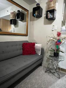 a couch in a room with a mirror and a table at Shell Residences in Sampong