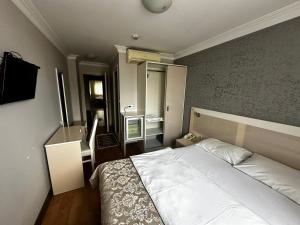 a bedroom with a large white bed in a room at Samsun Park Hotel in Samsun
