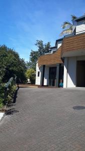 a house with a driveway in front of a building at Pukeko on Bay in Tauranga