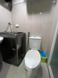 a bathroom with a white toilet and a sink at Shell Residences in Sampong +6 photos