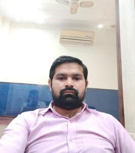 a man with a beard sitting in an office at Hotel Lotus Palace in Lucknow