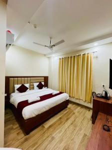 a bedroom with a large bed and a television at Hotel Lotus Palace in Lucknow