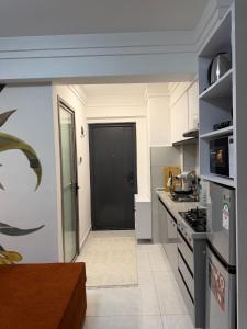 a kitchen with a black door and a stove top oven at Serenity Spot - Cozy 1 bedroom with AC and Heater with City View in Nairobi, Westlands in Nairobi