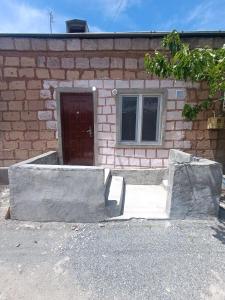 a brick house with a door and a window at Small home aeroport in Zakhmat