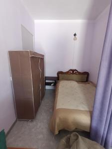 a small bedroom with a bed and a dresser at Small home aeroport in Zakhmat