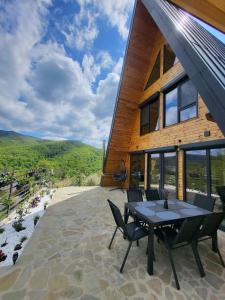 a house with a patio with a table and chairs at Hill House Doftana in Seciuri