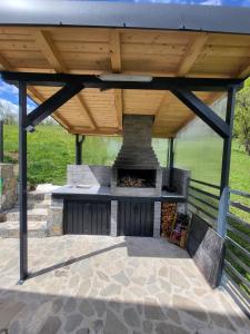 a patio with a fireplace under a wooden roof at Hill House Doftana in Seciuri