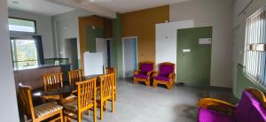 a waiting room with wooden chairs and purple chairs at Belmonte in Kalasa