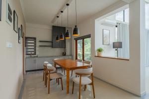 a kitchen and dining room with a wooden table and chairs at Boutique Dinu in Kandy