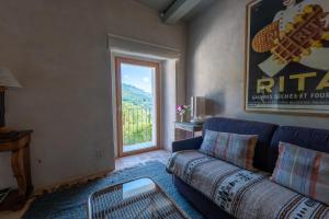 a living room with a couch and a large window at La Terrazza di Rivoria - Vue magique & Terrasse in Masera
