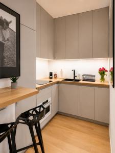 a kitchen with white cabinets and a wooden table at APARTAMENT 4 bed 2 room WARSAW in Warsaw