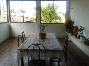 a table and chairs in a room with windows at Pousada Ana Poipa in Goiânia