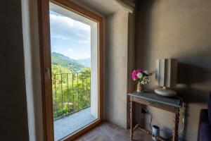 a room with a window with a view of a mountain at La Terrazza di Rivoria - Vue magique & Terrasse in Masera