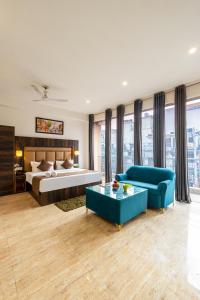 a large bedroom with a bed and a blue couch at Hotel Apple Tree - Near Mahipalpur Market in New Delhi