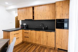 a kitchen with wooden cabinets and a black counter top at TRITA SK - Belanka in Spišská Belá
