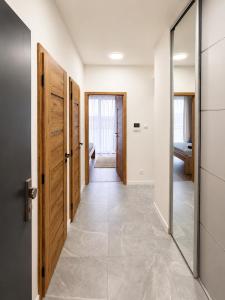a hallway with wooden doors and a mirror at TRITA SK - Belanka in Spišská Belá