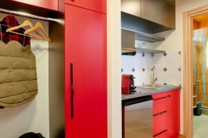 a kitchen with red cabinets and a red door at Olympia 3 in Xanthi +11 photos