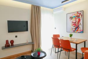 a living room with a table and chairs and a television at Olympia 3 in Xanthi