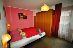 1 dormitorio rojo con 1 cama con sábanas rojas en Garni Gimea, en Livigno