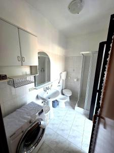 a bathroom with a toilet sink and a washing machine at Casa Cordara Apartment in Nizza Monferrato
