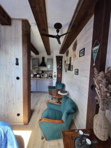 a living room with a table and chairs and a kitchen at Woodland Apartment Small in Berezka