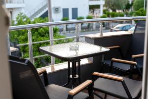a table and chairs on a balcony with a view of a street at Rexha Apartments in Ulcinj