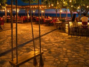 a group of people sitting at a restaurant at night at Assos Plus in Ayvacık