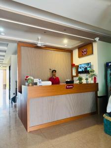 a man sitting at a counter in a hospital lobby at Rudraksh Hotel & Resturant in Lordi