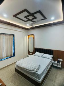 a bedroom with a bed and a mirror on the ceiling at Rudraksh Hotel & Resturant in Lordi